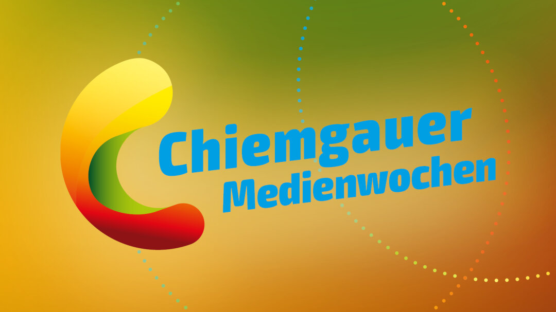 Eine gelbbraungrüne Fläche mit 3 kleingepunkteten Schnüren über dem Bild. In der linken Ecke das  Logo der Chiemgauer Medienwochen. Das Logo sieht aus wie eine Bohne mit einem tiefen grünen Knick in der Mitte, der obere gelbe Teil ist deutlich größer als der rote untere Teil. Rechts davon ein blauer Schriftzug 